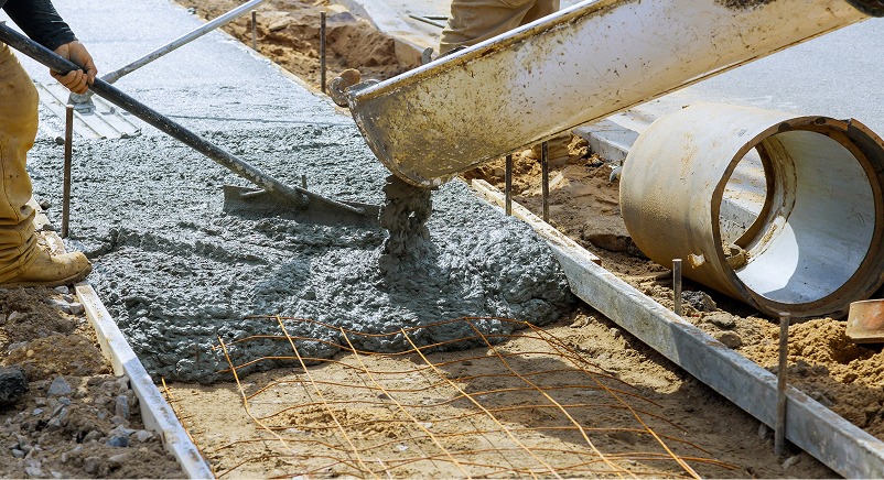 Workers pouring fresh concrete for a sidewalk or pathway