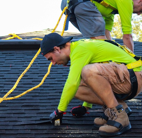 Roofers performing work on a shingled roof